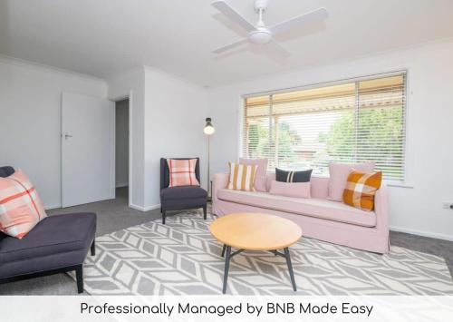 a living room with a couch and two chairs at Cadogan House - Professionally Styled in CBD in Orange