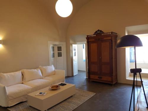 a living room with a white couch and a table at LIFE MANSION in OIA in Oia
