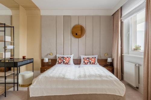 a bedroom with a large white bed with two pillows at Natura Luxury Apartments II in Iława