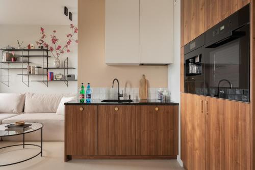a living room with a couch and a kitchen at Natura Luxury Apartments II in Iława