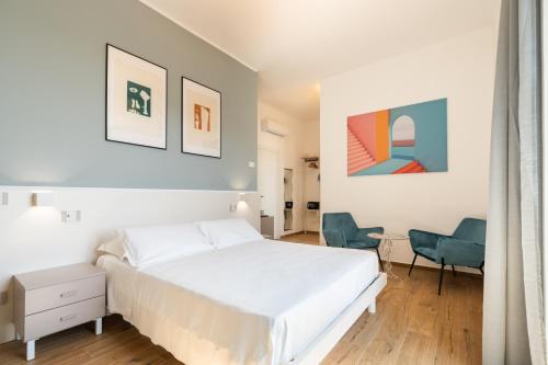 - une chambre blanche avec un lit et une chaise dans l'établissement Le camere sui colli, à La Spezia