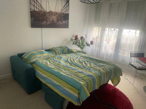 - une chambre avec un lit orné d'un vase de fleurs dans l'établissement Beau F1 lumineux et calme, à Chilly-Mazarin