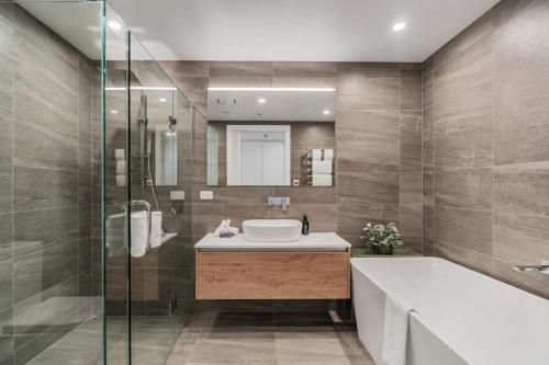 y baño con bañera, lavamanos y ducha. en Lakeview Luxuy Vista Suite, en Wanaka