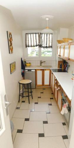 Il comprend une cuisine avec une table et du carrelage. dans l'établissement Beau F1 lumineux et calme, à Chilly-Mazarin