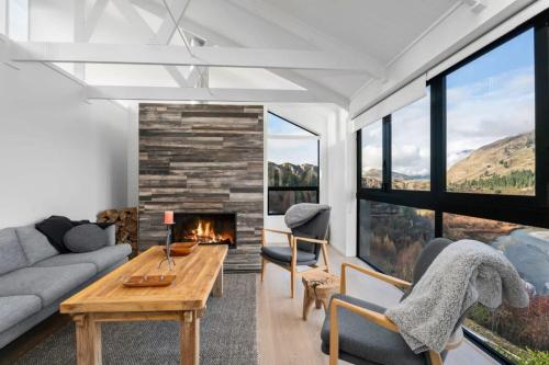 a living room with a couch and a fireplace at Chateau Shotover in Queenstown