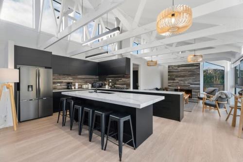 a kitchen with a large island with bar stools at Chateau Shotover in Queenstown