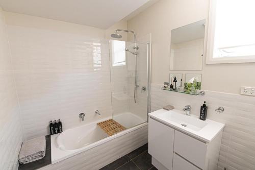 a white bathroom with a tub and a sink at Mortimer's Wines Studio - Adults Only Retreat in Orange