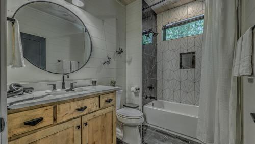 a bathroom with a sink and a toilet and a mirror at Holiday House in Blue Ridge