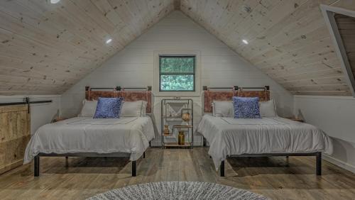 a attic bedroom with two beds and a window at Holiday House in Blue Ridge