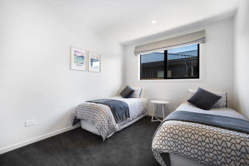 a bedroom with two beds and a window at Views from the Heights in Wanaka