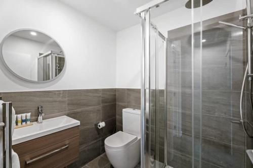 a bathroom with a toilet and a glass shower at Adventure Riverside Retreat in Albert Town