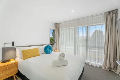 a bedroom with a large bed with a large window at Adventure Riverside Retreat in Albert Town