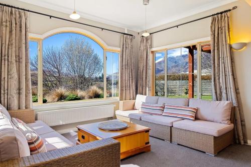 a living room with a couch and some windows at Paeroa View in Queenstown