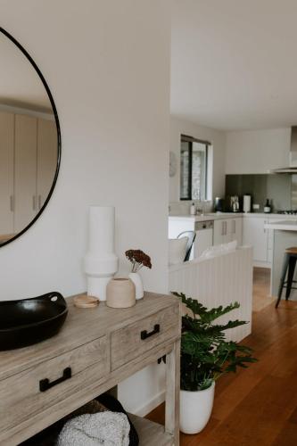 a living room with a table and a mirror at Dovecote: 5-bedroom Home with Hot tub & Games room in Arrowtown