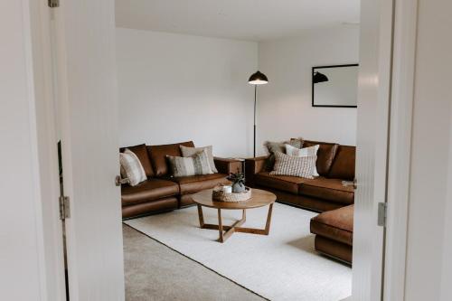 a living room with a couch and a table at Dovecote: 5-bedroom Home with Hot tub & Games room in Arrowtown