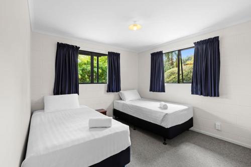 Pohara的住宿－Paradise in Pohara，一间卧室设有两张床和两个窗户。