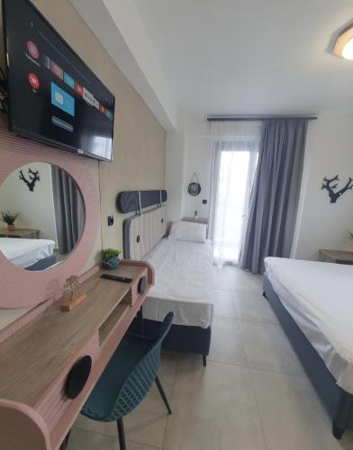 a hotel room with two beds and a mirror at Olea Luxury Suites in Asprovalta