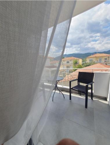 a chair sitting on a balcony with a window at Olea Luxury Suites in Asprovalta