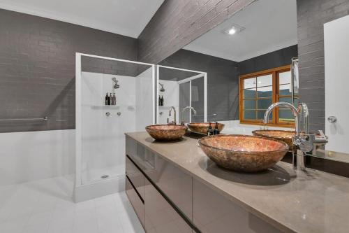 łazienka z 2 umywalkami i prysznicem w obiekcie Snowline - Ultimate Getaway, Pool & Spa, Sleeps 16 w mieście Canobolas