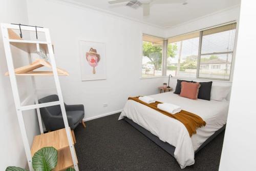 um quarto com uma cama, uma escada e uma cadeira em Haven on Hill, Beautifully renovated, Close to CBD em Orange