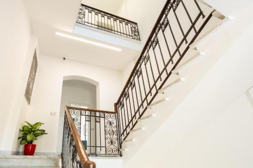 a staircase in a house with white walls and wooden railings at Le camere sui colli in La Spezia