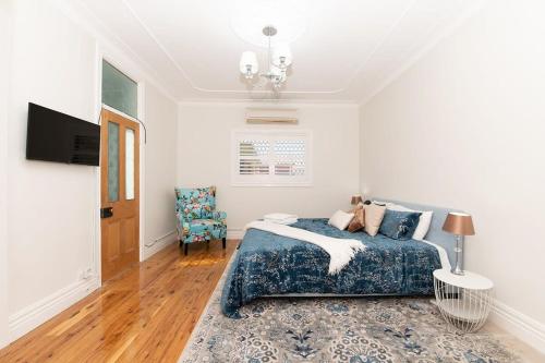a bedroom with a bed and a table and a chair at Secret Cottage - Charming & Lovingly Restored, Firepit in Orange