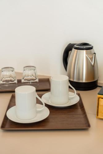 two cups on a wooden tray with a tea kettle at Le camere sui colli in La Spezia