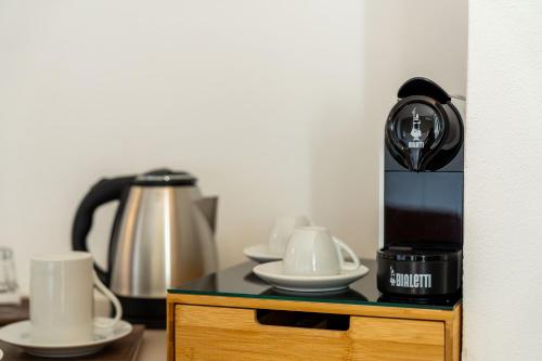 a table with a coffee maker and cups on it at Le camere sui colli in La Spezia