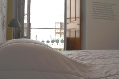 a white bed in a room with a window at Hostel 2300 Thomar in Tomar