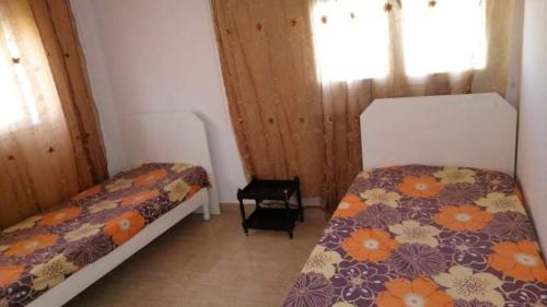 mały pokój z 2 łóżkami i oknem w obiekcie Appartement S+2 richement meublé et climatisé w mieście Potinville