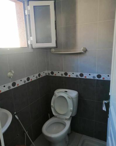 łazienka z toaletą i umywalką w obiekcie Appartement S+2 richement meublé et climatisé w mieście Potinville