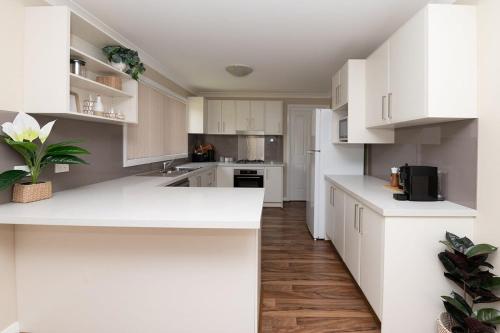 a kitchen with white cabinets and a white counter top at Phillip Villa, Modern & Fresh, Close to Town, Free Wifi in Orange