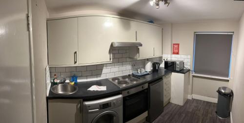a small kitchen with a sink and a dishwasher at Clocktower Apartment in Kent