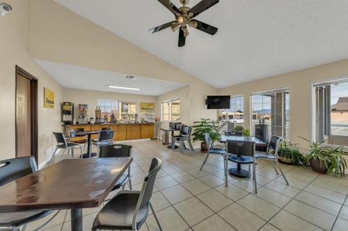 Days Inn by Wyndham Carson City في كارسون سيتي: غرفة طعام مع طاولات وكراسي ومروحة سقف