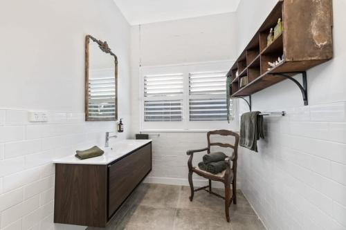 a bathroom with a sink and a chair at Loft House - On Heifer Station Vineyard in Borenore