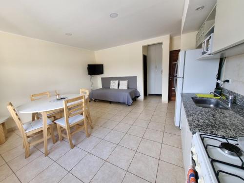 eine Küche und ein Wohnzimmer mit einem Tisch und einem Bett in der Unterkunft Confortable Departamento Salta in Salta
