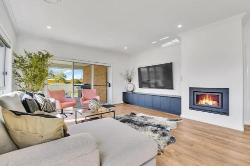 Una televisión o centro de entretenimiento en Hideaway on Curran - Modern & Comfy Retreat in CBD Firepit