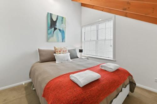 a bedroom with a large bed with a red blanket at Peel St - Large Family Home Walk to CBD in Bathurst