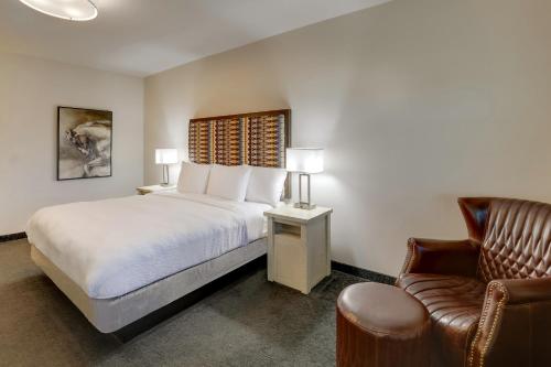 a bedroom with a bed and a chair and a couch at Stoney Creek Hotel Tulsa - Broken Arrow in Broken Arrow