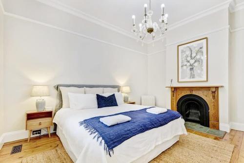a bedroom with a large bed and a fireplace at Kilarra House - Heritage Home on Byng St Sleeps 10 in Orange