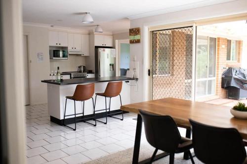 a kitchen and dining room with a table and chairs at The Valerie Gardens - Homely & Cosy, Sleeps 11 in Orange