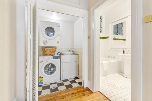 a white laundry room with a washer and dryer at Kilarra House - Heritage Home on Byng St Sleeps 10 in Orange