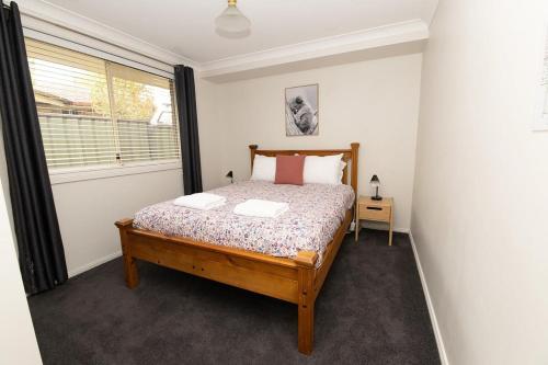 a bedroom with a bed and a window at The Valerie Gardens - Homely & Cosy, Sleeps 11 in Orange