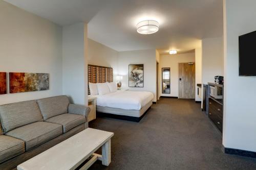 a hotel room with a bed and a couch at Stoney Creek Hotel Tulsa - Broken Arrow in Broken Arrow
