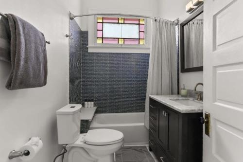 ニューオーリンズにあるBeautiful Historic Mid City Homeのバスルーム(トイレ、シャワー付)、窓が備わります。