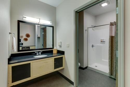 a bathroom with a sink and a mirror and a shower at Stoney Creek Hotel Tulsa - Broken Arrow in Broken Arrow