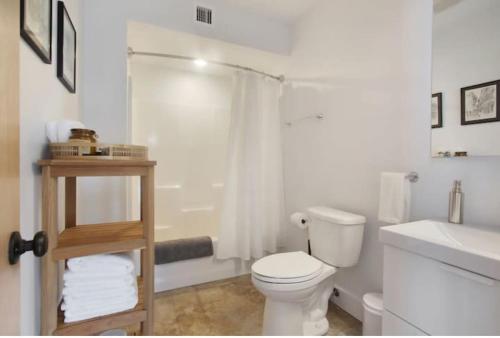 a white bathroom with a toilet and a sink at River Breeze Quiet & Modern Black Pearl Apartment in New Orleans