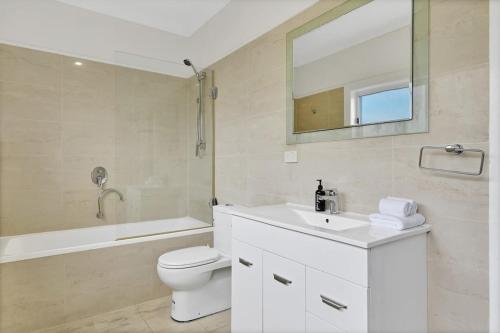 y baño con lavabo, aseo y espejo. en Kinross Cottage Close to CBD Comfy & Convenient en Orange