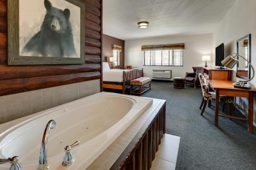 un bagno con vasca e una camera da letto di Stoney Creek Hotel Tulsa - Broken Arrow a Broken Arrow