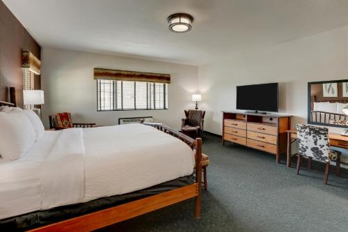 a bedroom with a bed and a flat screen tv at Stoney Creek Hotel Tulsa - Broken Arrow in Broken Arrow